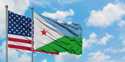 United States and Djibouti flag waving in the wind against white cloudy blue sky together. Diplomacy concept, international relations.