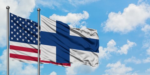 United States and Finland flag waving in the wind against white cloudy blue sky together. Diplomacy concept, international relations.