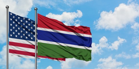 United States and Gambia flag waving in the wind against white cloudy blue sky together. Diplomacy concept, international relations.