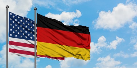 United States and Germany flag waving in the wind against white cloudy blue sky together. Diplomacy concept, international relations.