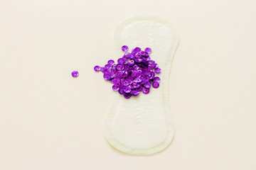 Female laying with violet spangles. Hygiene concept menstruation/ Monthly uterine bleeding in women.