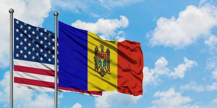 United States and Moldova flag waving in the wind against white cloudy blue sky together. Diplomacy concept, international relations.