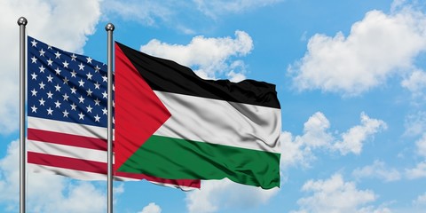United States and Palestine flag waving in the wind against white cloudy blue sky together. Diplomacy concept, international relations.