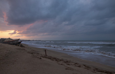 sunset at sea during a storm on the shore of a fishing boat