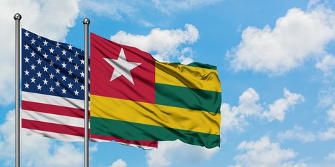 United States and Togo flag waving in the wind against white cloudy blue sky together. Diplomacy concept, international relations.