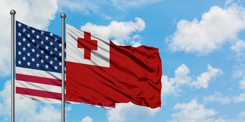 United States and Tonga flag waving in the wind against white cloudy blue sky together. Diplomacy concept, international relations.