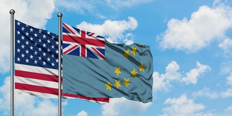 United States and Tuvalu flag waving in the wind against white cloudy blue sky together. Diplomacy...