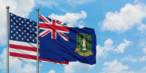 United States and British Virgin Islands flag waving in the wind against white cloudy blue sky together. Diplomacy concept, international relations.