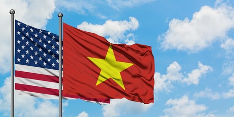 United States and Vietnam flag waving in the wind against white cloudy blue sky together. Diplomacy concept, international relations.
