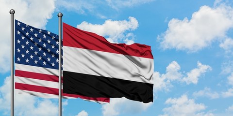 United States and Yemen flag waving in the wind against white cloudy blue sky together. Diplomacy concept, international relations.