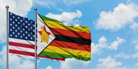 United States and Zimbabwe flag waving in the wind against white cloudy blue sky together. Diplomacy concept, international relations.