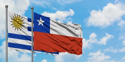 Uruguay and Chile flag waving in the wind against white cloudy blue sky together. Diplomacy concept, international relations.