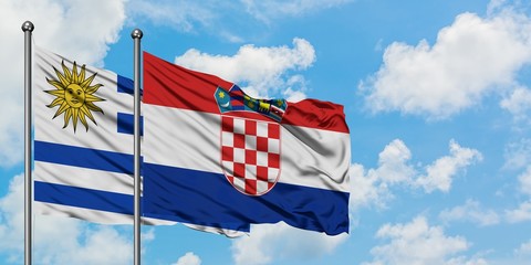 Uruguay and Croatia flag waving in the wind against white cloudy blue sky together. Diplomacy concept, international relations.
