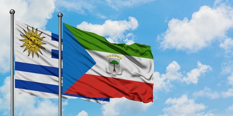 Uruguay and Equatorial Guinea flag waving in the wind against white cloudy blue sky together. Diplomacy concept, international relations.