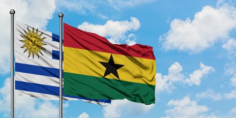 Uruguay and Ghana flag waving in the wind against white cloudy blue sky together. Diplomacy concept, international relations.