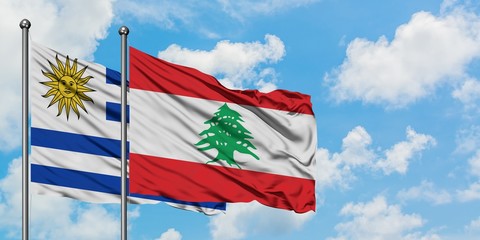 Uruguay and Lebanon flag waving in the wind against white cloudy blue sky together. Diplomacy concept, international relations.