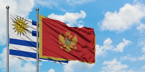 Uruguay and Montenegro flag waving in the wind against white cloudy blue sky together. Diplomacy concept, international relations.