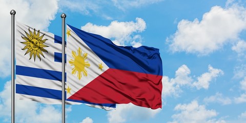 Uruguay and Philippines flag waving in the wind against white cloudy blue sky together. Diplomacy concept, international relations.