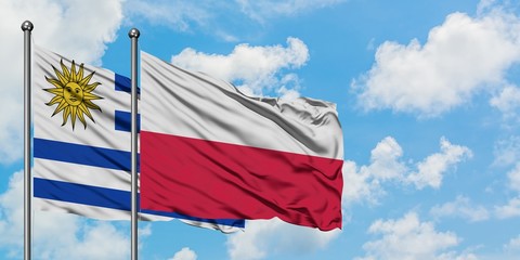 Uruguay and Poland flag waving in the wind against white cloudy blue sky together. Diplomacy concept, international relations.