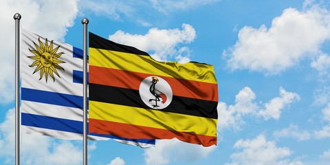 Uruguay and Uganda flag waving in the wind against white cloudy blue sky together. Diplomacy concept, international relations.