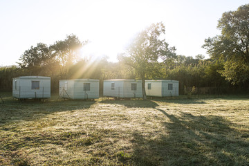 Some bungalows in a row in a green landscape camping with sun shining morning