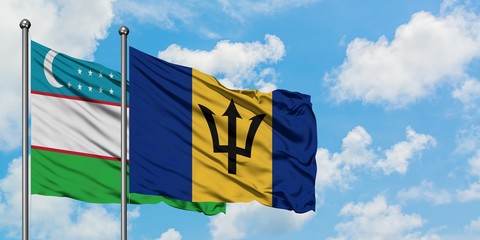 Uzbekistan and Barbados flag waving in the wind against white cloudy blue sky together. Diplomacy concept, international relations.