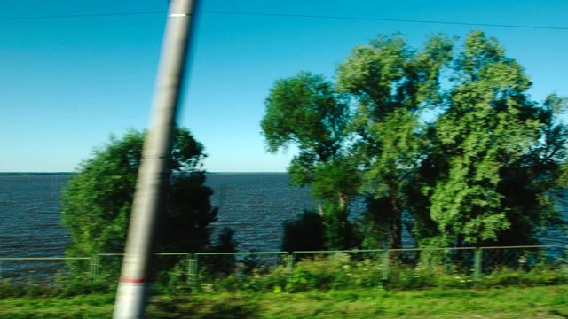 High-speed Train moves past a lake in a summer day