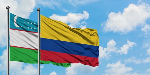 Uzbekistan and Colombia flag waving in the wind against white cloudy blue sky together. Diplomacy concept, international relations.