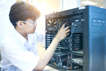 Male motherboard repairer using a screwdriver to replace the motherboard Concept of computer...