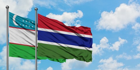 Uzbekistan and Gambia flag waving in the wind against white cloudy blue sky together. Diplomacy concept, international relations.