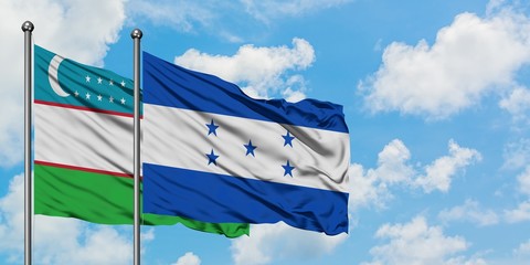 Uzbekistan and Honduras flag waving in the wind against white cloudy blue sky together. Diplomacy concept, international relations.