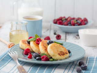 Cottage cheese pancakes with sour cream and tea. Gourmet Breakfast - Cottage cheese pancakes, syrniki, curd fritters in a white plate. Russian syrniki or sirniki, cottage cheese fritters.