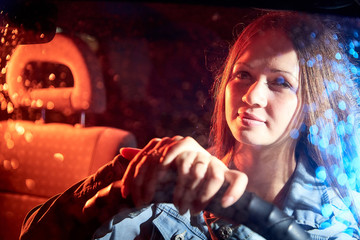 Beautiful young woman in the car at night