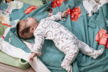 Asian baby roll over on play mat