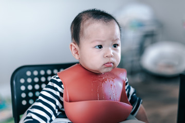 Little asian baby boy with red bib waiting food