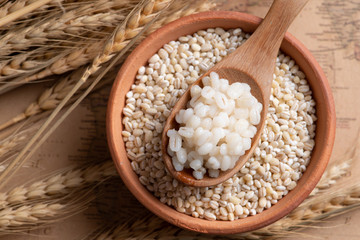Cooked peeled barley grains in wooden bowl