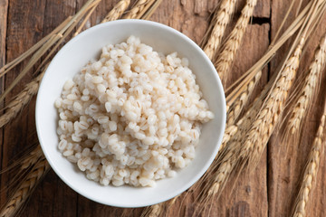 Cooked peeled barley grains in white bowl