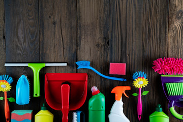 Autumn house cleaning theme.  Colorful cleaning products on rustic wooden table. Top view shot. Place for typography.