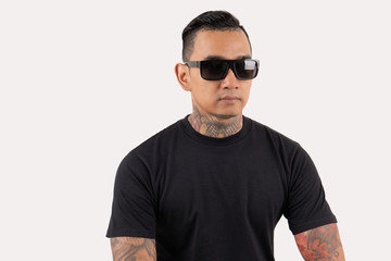 Man tattooed wearing black t-shirt and sunglasses isolated on background.