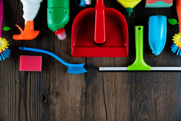 Autumn house cleaning theme.  Colorful cleaning products on rustic wooden table. Top view shot. Place for typography.