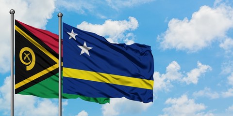 Vanuatu and Curacao flag waving in the wind against white cloudy blue sky together. Diplomacy concept, international relations.