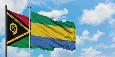 Vanuatu and Gabon flag waving in the wind against white cloudy blue sky together. Diplomacy concept, international relations.