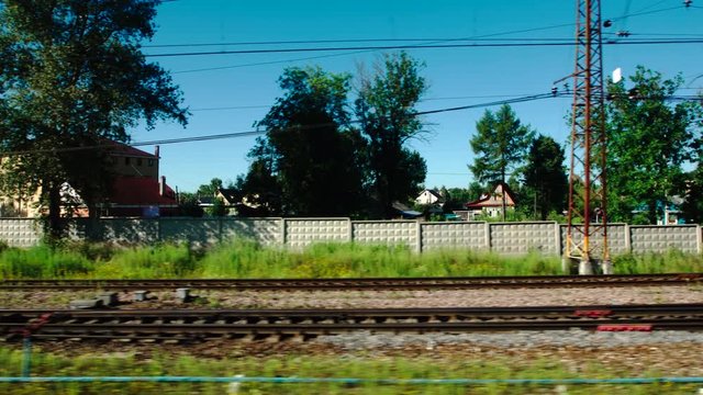 High-speed Train moves past a railway station in a small town in the summer