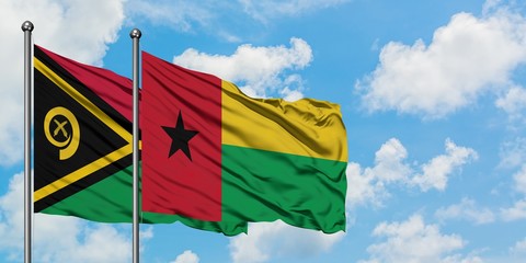 Vanuatu and Guinea Bissau flag waving in the wind against white cloudy blue sky together. Diplomacy concept, international relations.