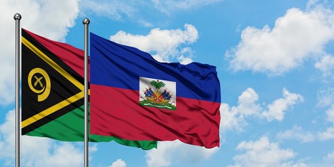 Vanuatu and Haiti flag waving in the wind against white cloudy blue sky together. Diplomacy...