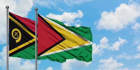Vanuatu and Guyana flag waving in the wind against white cloudy blue sky together. Diplomacy concept, international relations.
