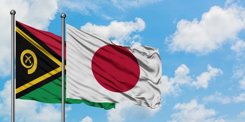 Vanuatu and Japan flag waving in the wind against white cloudy blue sky together. Diplomacy...