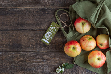 Apples and cotton bag with a label 100 natural product. Organic stuff. View from above. Close-up.