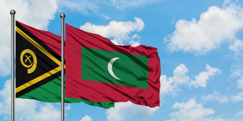 Vanuatu and Maldives flag waving in the wind against white cloudy blue sky together. Diplomacy...