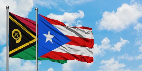 Vanuatu and Puerto Rico flag waving in the wind against white cloudy blue sky together. Diplomacy concept, international relations.